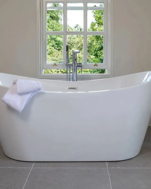 A freestanding bath under a window
