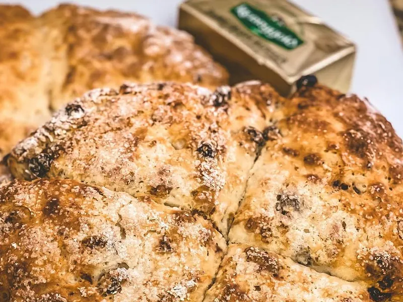 Traditional Irish soda bread scored in a cross, with Kerrygold Irish butter