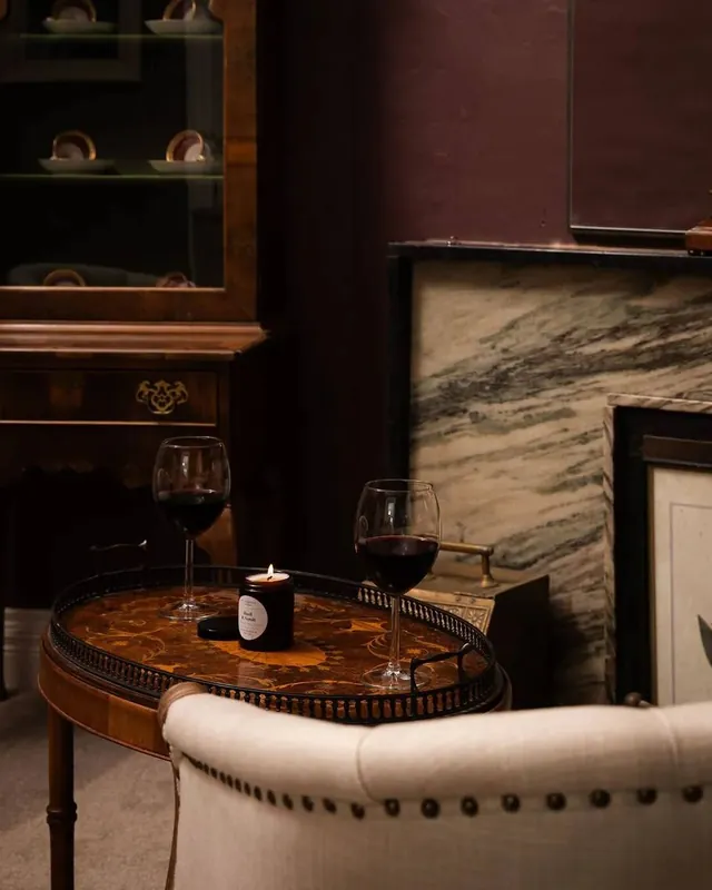 Armchairs and two glasses of red wine by the fire in the study