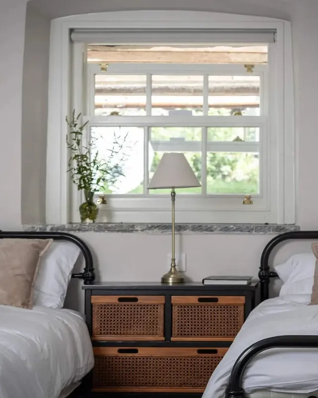 A twin bedroom with two beds under a window